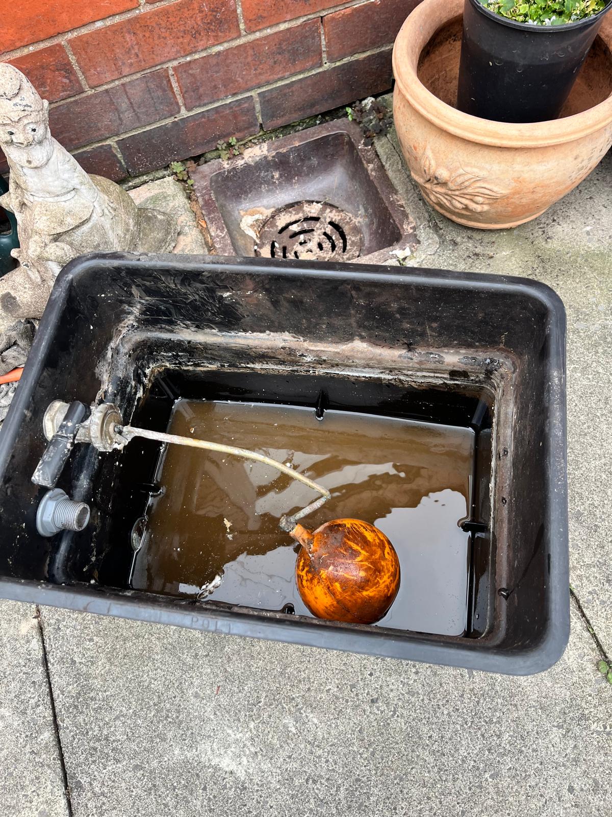Old feed and expansion tank with corroded ball valve causing central heating problems and boiler overheating in Bolton