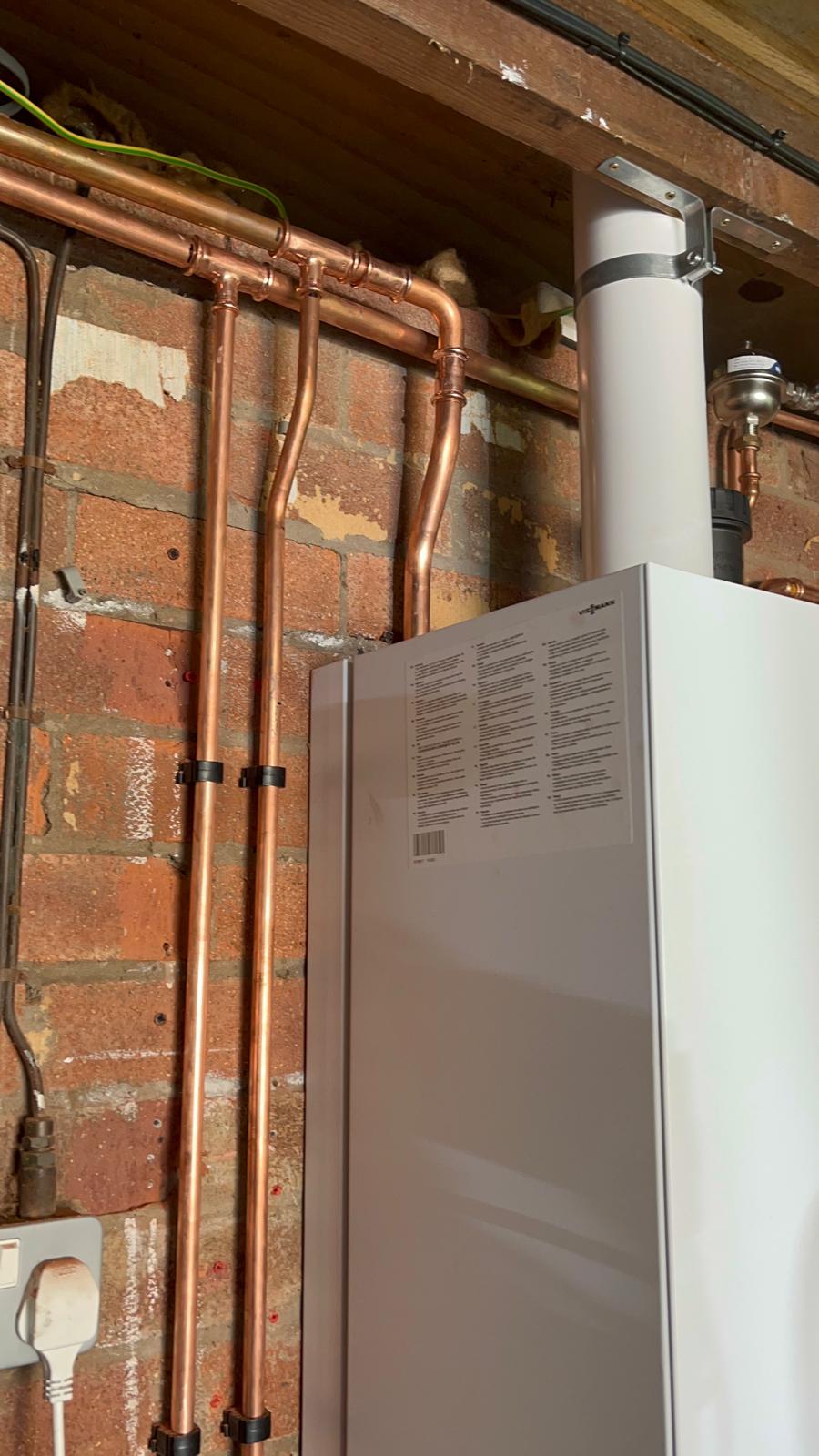 New combi boiler installed beside upgraded gas meter and copper gas supply pipework