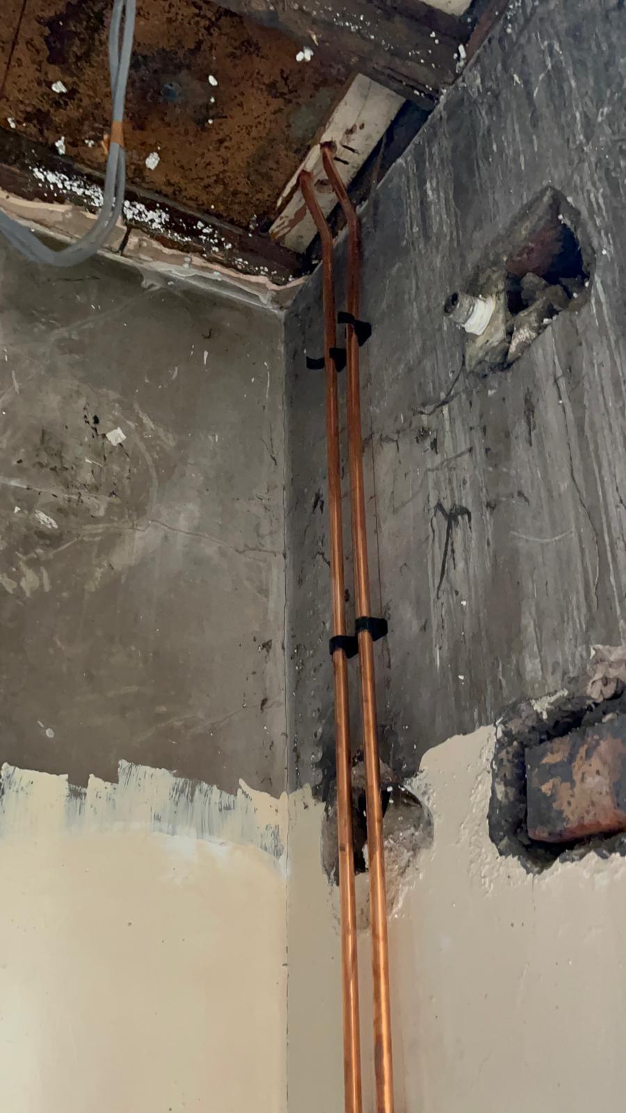 Heating pipework chased vertically into plaster ready for new radiators in a Bolton property