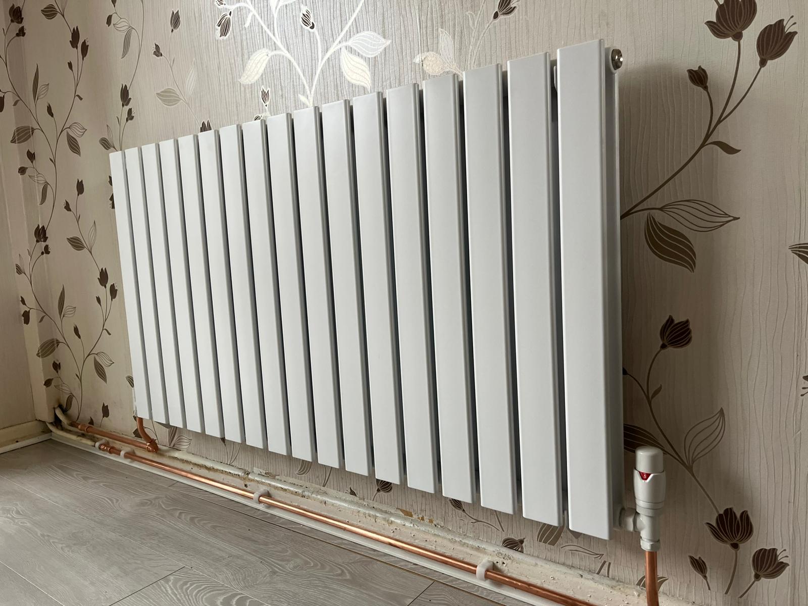 Modern white flat panel radiator installed with thermostatic valve in Manchester