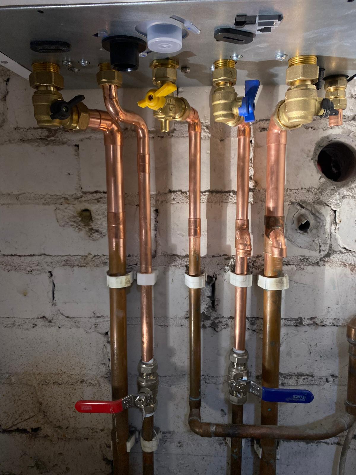 Copper pipework connections with isolation valves under a boiler